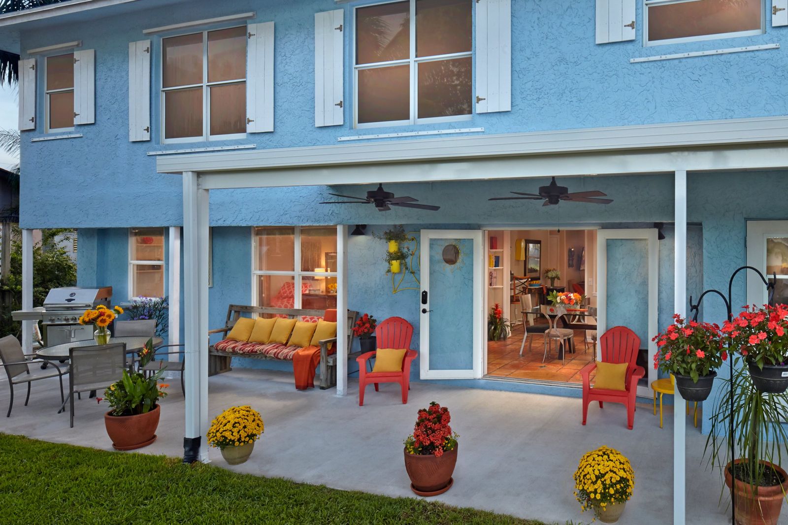 Covered back patio with seating, grill, and dining table